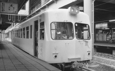 Yolcu treninin yer aldığı bir kamu istasyonunun siyah beyaz fotoğrafı.