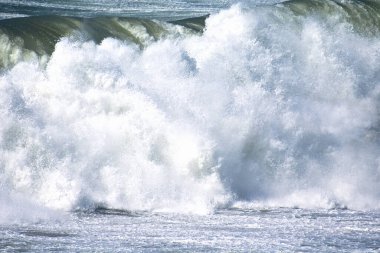 Denizdeki dalgaların gündüz görüntüsü. Denizin üzerindeki mavi gökyüzü