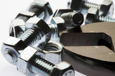 Beyaz arkaplanda metal cıvatalar ve fındıklar.