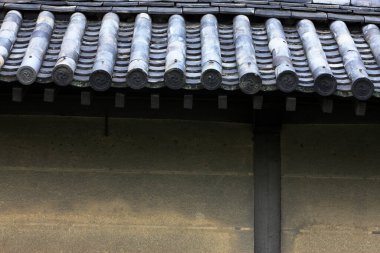 Geleneksel Japon inşaat duvarını kaplayan eskimiş seramik kiremitler.