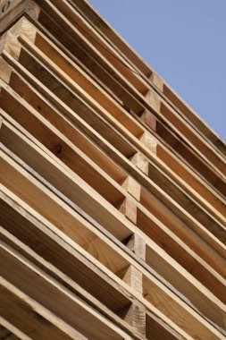 Temiz mavi gökyüzünün altında istiflenmiş ahşap paletler