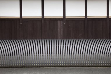 Modern mimaride ahşap duvara karşı eğri metal korkuluklar.