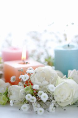 Yakıcı mumların ve parlak arkaplanda güzel beyaz çiçeklerin yakın plan görüntüsü                                   