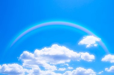 Gökyüzünde gökkuşağıyla mavi ve beyaz bulutlar