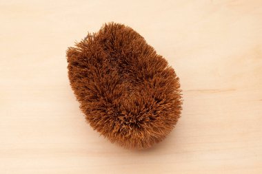 Brown scrubbing brush resting on wooden surface