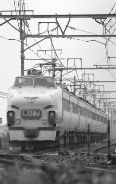 Tren raylar boyunca ilerliyor. siyah ve beyaz fotoğraf olay yerini yakalıyor.