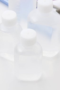 Beyaz yüzeyde şeffaf sıvı içeren plastik şişeleri temizle