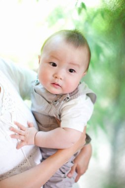 Annesi dışarıda olan tatlı Asyalı bir erkek bebek.