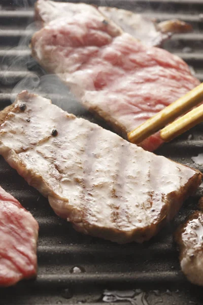 用筷子把肉放在烤架上 烤肉很好吃 — 图库照片