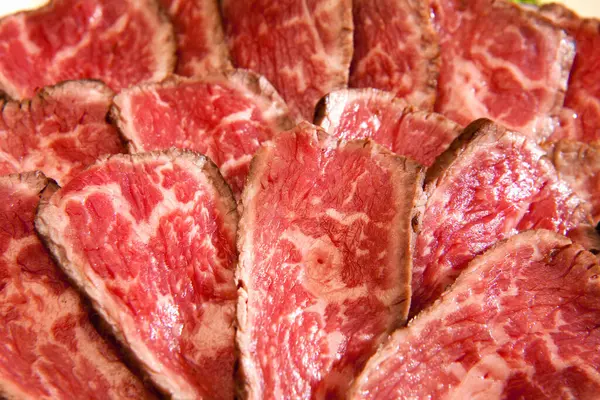 a plate of sliced kobe meat on background, close up