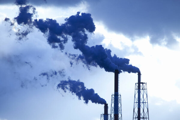 smoke from chimneys of industrial factory against sky       