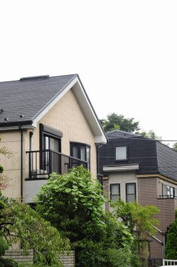 Etrafı yemyeşil ağaçlarla çevrili balkonların olduğu modern meskenler.