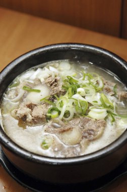 Lezzetli Asya yemeklerinin yakın görüntüsü. Etli çorba ve dilimlenmiş yeşil soğan. 