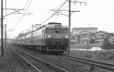 Tren raylarında giden bir trenin siyah beyaz fotoğrafı..