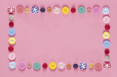 Pembe arkaplandaki renkli düğmelerin üst görünümü   