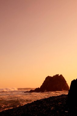 Kayalık deniz kıyısında güzel bir gün batımı. Doğa arkaplanı