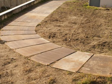 Kuru topraktaki taş levhalardan yapılmış kıvrımlı yollar.