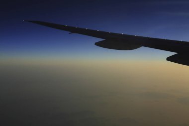 Gökyüzündeki bulutların üzerinde uçan bir uçağın kanadı        