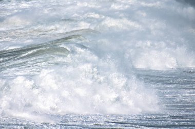 Denizdeki dalgaların gündüz görüntüsü. Denizin üzerindeki mavi gökyüzü