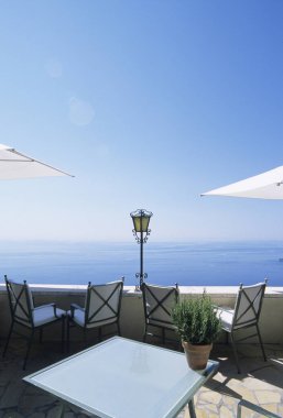 Deniz kıyısının güzel manzarası ve masaları ve sandalyeleri olan açık bir kafe. 