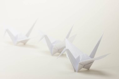 Işık arkaplanındaki origami kağıt kuşları