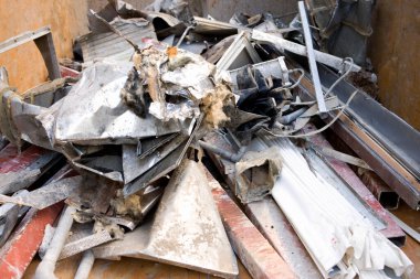 Piled scrap metal debris in large industrial dumpster