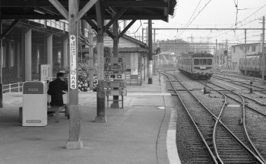 Halka açık bir istasyonda yolcu treni. Siyah beyaz fotoğraf.