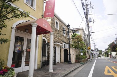 Geniş şehir caddesi gündüz binalarla çevrili.