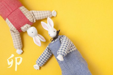 Sarı arka planda sevimli oyuncak tavşanlar, el yapımı konsept. 