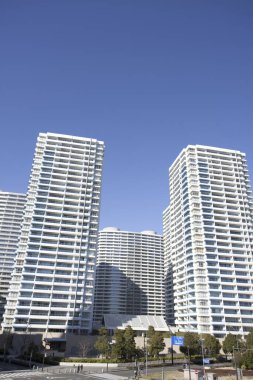Tokyo 'da parlak mavi gökyüzünün altında uzun, parlak binalar..