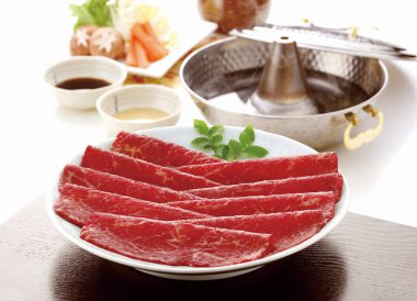 taze ve çiğ et dilimleri sosla servis edilir.