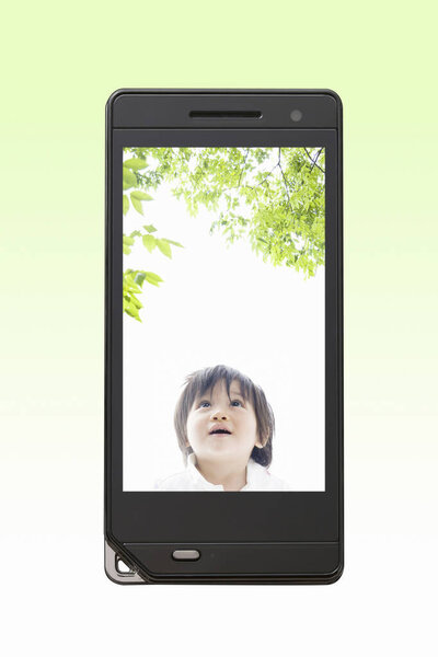 portrait of beautiful asian kid on the mobile phone screen