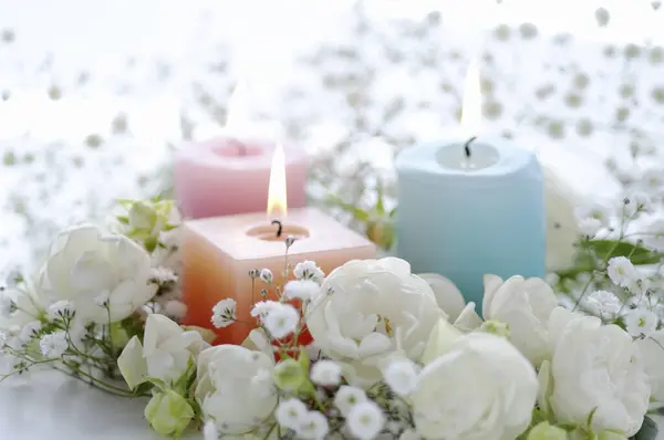 Close Zicht Brandende Kaarsen Mooie Witte Bloemen Lichte Achtergrond — Stockfoto