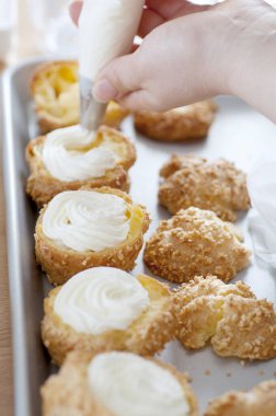 Profiterolleri kremayla dolduran kadına yakın dur.