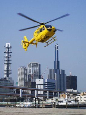 Helikopter mavi gökyüzünde doğa arka planında uçuyor