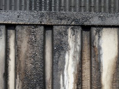 Paslanmış metal paneller paslanma ve aşınma izlerini gösteriyor.