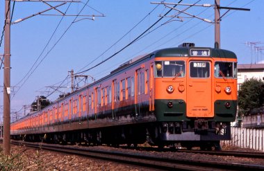 Tren Japonya 'da gün batımında demiryolunda hareket ediyor.