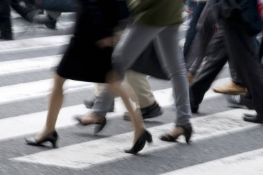 Şehirde yürüyen insanların bacaklarının bulanık hareket görüntüsü                 