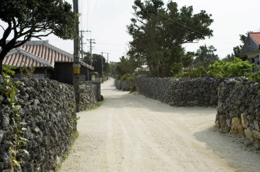 Taş duvarlar ve geleneksel evlerle dolu sessiz bir kırsal sokak.