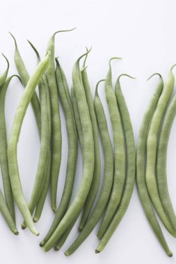 Beyaz arkaplanda çiğ yeşil organik fasulye