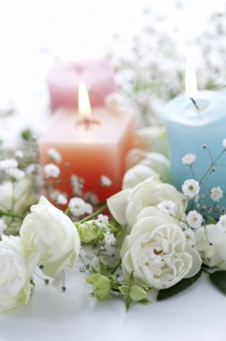 Yakıcı mumların ve parlak arkaplanda güzel beyaz çiçeklerin yakın plan görüntüsü                                   