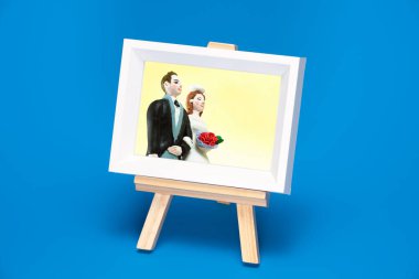 Çerçeveli düğün fotoğrafı ahşap sehpada dinleniyor.