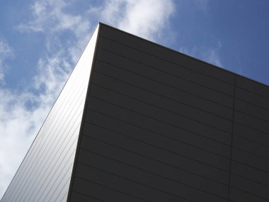 Modern bina cephesi ve mavi gökyüzünün düşük açılı görüntüsü     