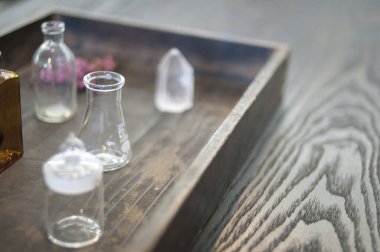 Kırsal ahşap tepside duran küçük cam şişeler.