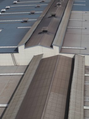 Geometrik metal kalıplarını tekrarlayan büyük sanayi deposu çatısı