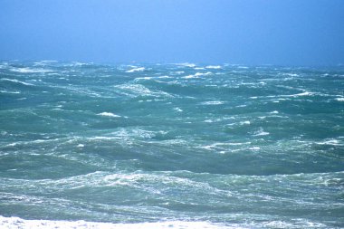 Denizdeki dalgaların gündüz görüntüsü. Denizin üzerindeki mavi gökyüzü