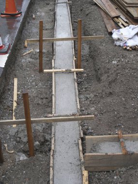 İnşaat alanındaki ahşap formlar arasında taze beton temel