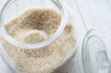 Tahta masada çiğ pirinçli cam kavanoz.