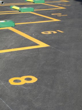 Asfalt yüzeyinde numaralandırılmış sarı park yerleri