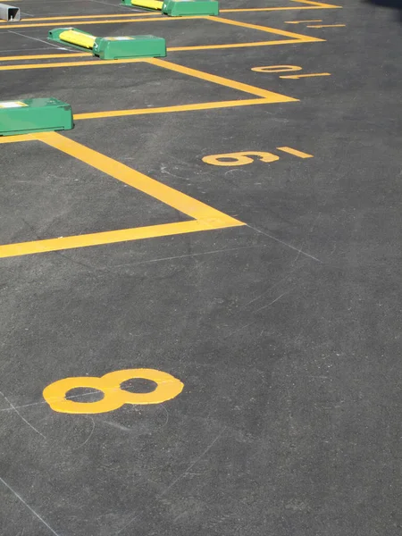 Asfalt yüzeyinde numaralandırılmış sarı park yerleri